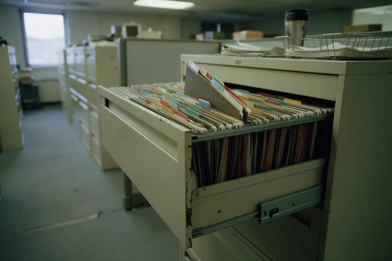 An open filing cabinet drawer packed with tabbed claim files.